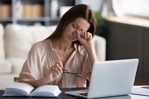 A woman battling with the effects of Meibomian Gland Dysfunction