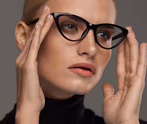 Close up of a woman in black turtleneck holding glasses
