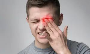 Man with headache holding his face in pain