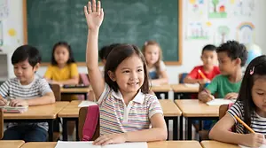 A group of children sitting in a classroom with a girl raising her hand.