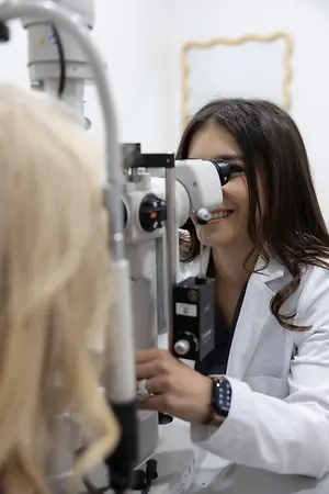 Optometrist examining a patient's eye with a slit lamp