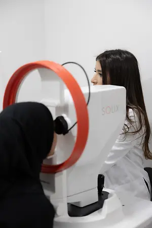 Optometrist examining a patient with a SOLOS eye imaging device