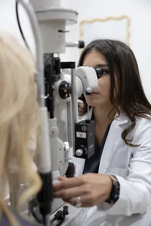 Optometrist examining a patient's eye with a slit lamp