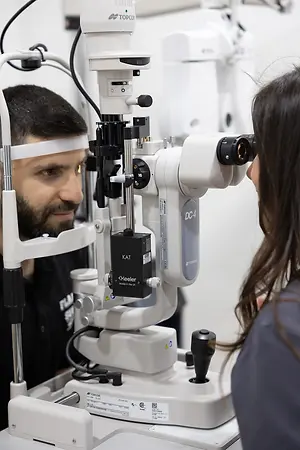 Optometrist examining a patient with a slit lamp microscope