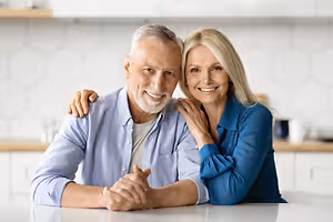 A smiling older man and woman in a kitchen setting