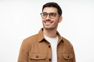 Man wearing glasses and a brown jacket, smiling and looking to the side