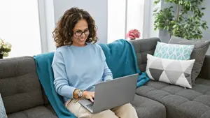 Woman sitting on a couch and working on a laptop