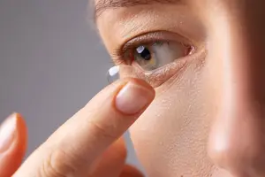 Woman placing a contact lens on her eye