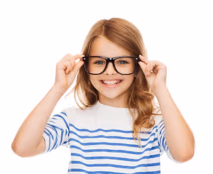 A girl wearing glasses is smiling and posing for a photo.