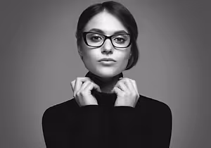 black and white portrait of a woman wearing glasses and a black turtleneck shirt