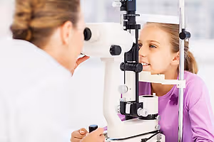 A little girl is having her eyes examined by an eye doctor in an eye clinic.