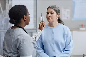 A doctor checking the patient's eye using a penlight