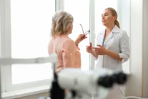 Two women in a room, one appears to be a doctor and the other a patient