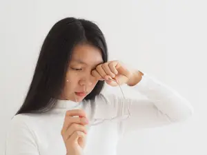 Woman adjusting her glasses while looking away