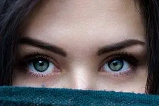 Close-up of a woman's face with her eyes covered by a blue towel