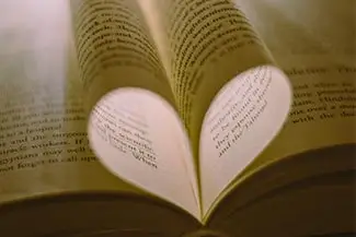 An open book with pages folded into the shape of a heart
