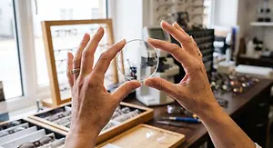 Optician holding an eyeglass frame in a store