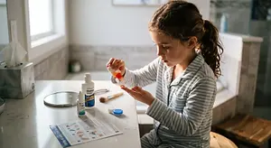 Child dispensing eye drops into her hand beside an eye care guide
