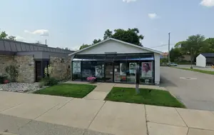 Image of a commercial building on a street corner with a closed sign