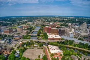 Aerial view of a city with many buildings, trees, and a river.