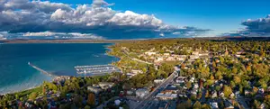 Aerial view of Traverse City, Michigan with a lake, a pier, and numerous buildings and trees