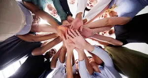 Group of people in a circle with their hands stacked on top of each other