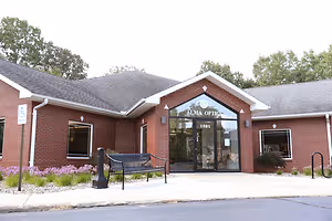 An image of Alma Optic's store with a bench outside