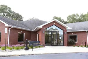 An image of Alma Optic's store with a bench outside