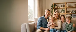 Smiling family of five sitting together on a sofa at home