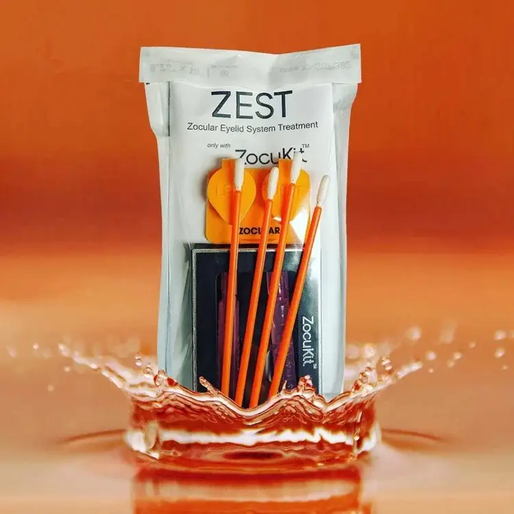 A Zest Zocuki Eyelid System Treatment package with a splash of liquid on an orange background
