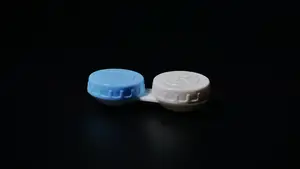 A closeup of a blue and white lens case on a black background