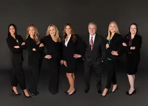 A group of people in formal wear are posing for a photo