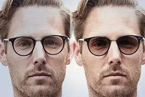 A man wearing a pair of glasses, with a beard, is looking straight at the camera, while the other man is wearing sunglasses and looking to the side