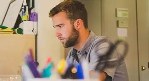 A man sitting and working at his desk looking at his computer