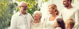 A happy family is standing in a garden and posing for a photo