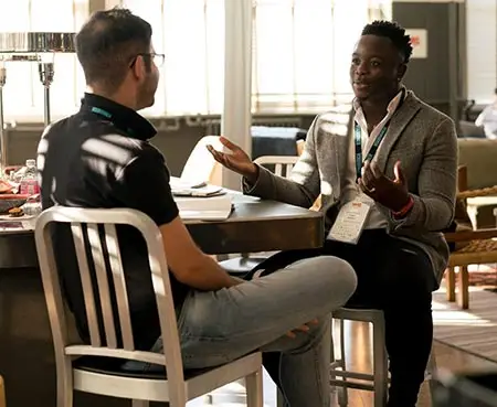 two men having a conversation in a modern interior setting