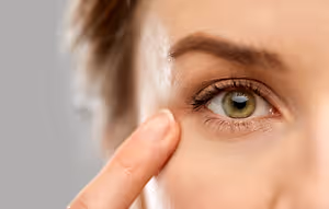 Close up of a woman's face with her hand touching her eye