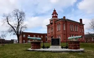 Red brick building with a clock tower and cannons on display