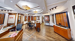 A room with wooden floors, a ceiling with lamps, and furniture such as chairs and tables.