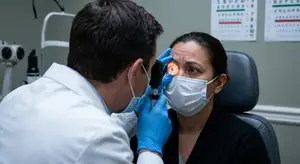 A doctor examining a patient's eye in a clinic.