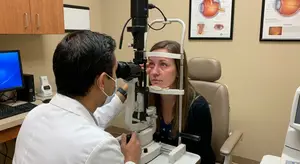 An eye doctor examines a patient's eye in an eye clinic