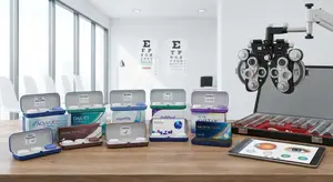 A wooden desk has an eye examination kit on it, as well as boxes of colored contact lenses.