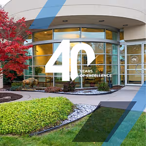 Exterior of a building with the words 40 Years of Excellence on the front and a buffalo statue in front of it.