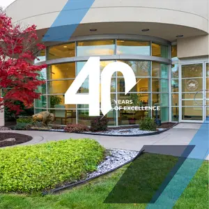 Exterior of a building with the words 40 Years of Excellence on the front and a buffalo statue in front of it.