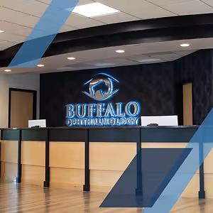 Buffalo Ophthalmology interior with a logo on the wall and a wooden reception desk.
