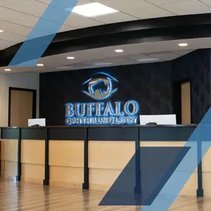 Buffalo Ophthalmology interior with a logo on the wall and a wooden reception desk.