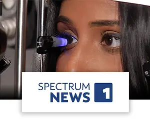 An image of a woman having her eyes checked, with the Spectrum News logo in the bottom.