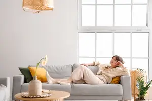 A woman lying on a couch in a living room with a smile on her face