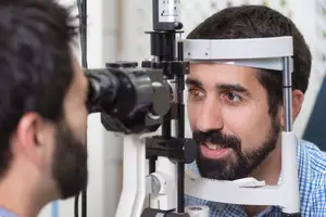 A man is having his eyes examined by an eye doctor.