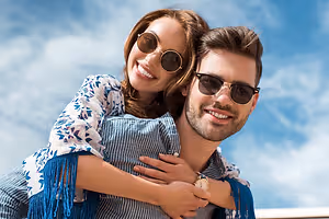 young couple wearing sunglasses on the beach
